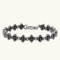 Oxidized 925 sterling silver bracelet with fleur-de-lis cross links and lobster clasp, 8.2mm wide on white background.