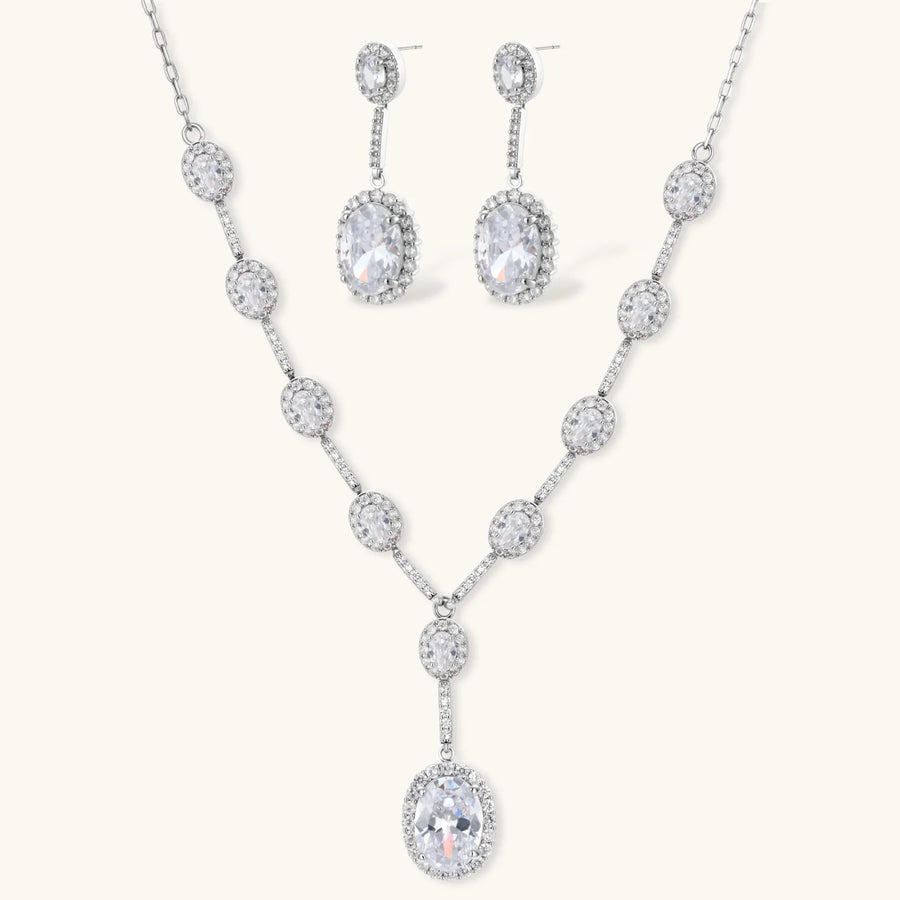 Elegant white gold plated jewelry set with oval cubic zirconia stones in halo settings, featuring Y-necklace and drop earrings.